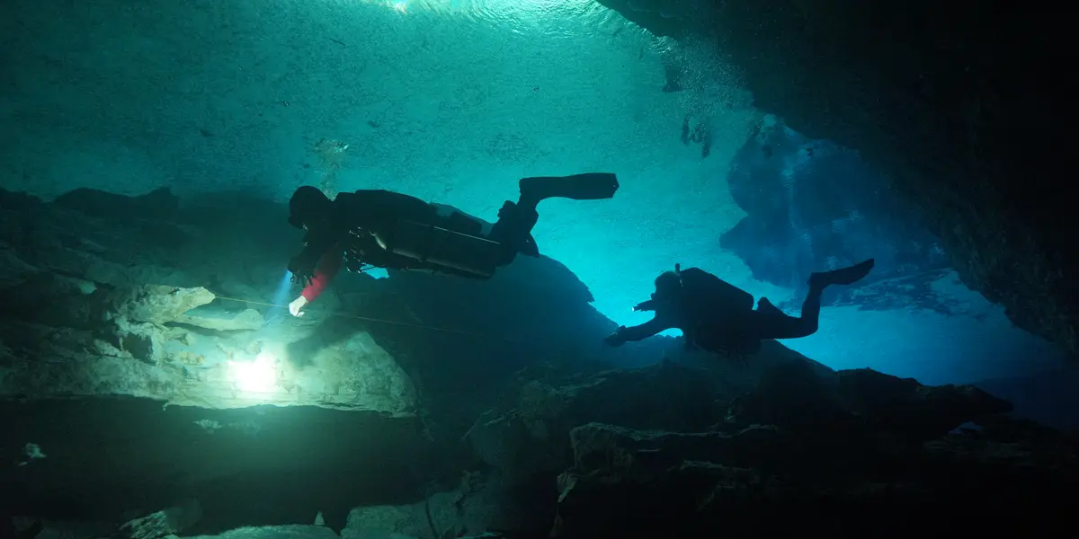 Cave-certified diver swimming through a passage at Chikin Ha