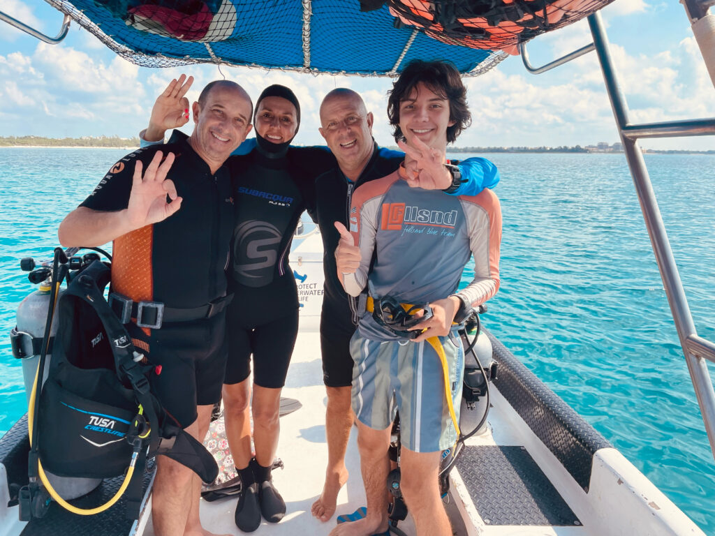 Divers celebrating aboard Deep México's boat during the best time to dive in Playa del Carmen